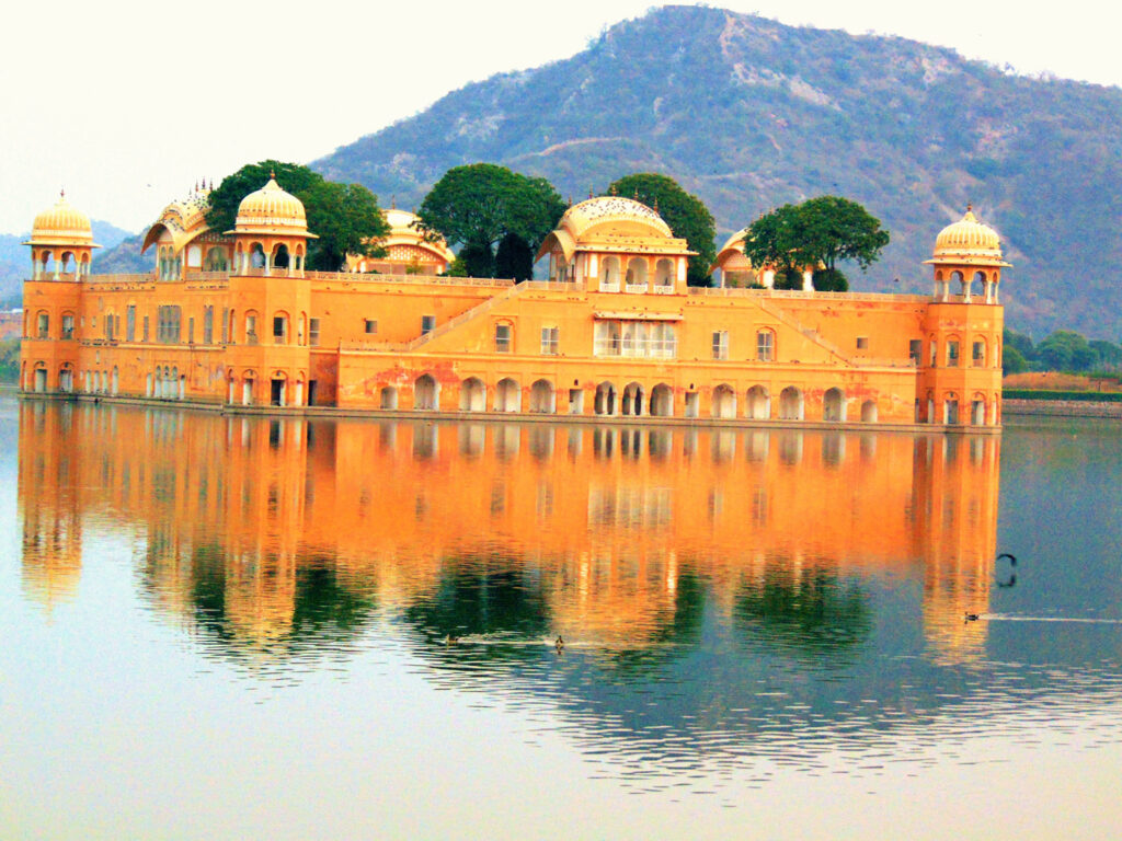 Jal Mahal Jaipur during winter morning, calm lake view with clear sky and sunlight, showcasing the Water Palace at its most beautiful season.