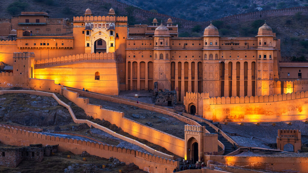Amer Fort Jaipur in winter morning, golden sunlight over majestic walls with clear blue sky, ideal season for exploring Rajasthan’s royal beauty.